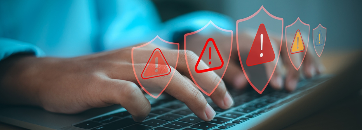Man achter laptop krijgt alert meldingen met de icoontjes van rode driehoeken en uitroeptekens